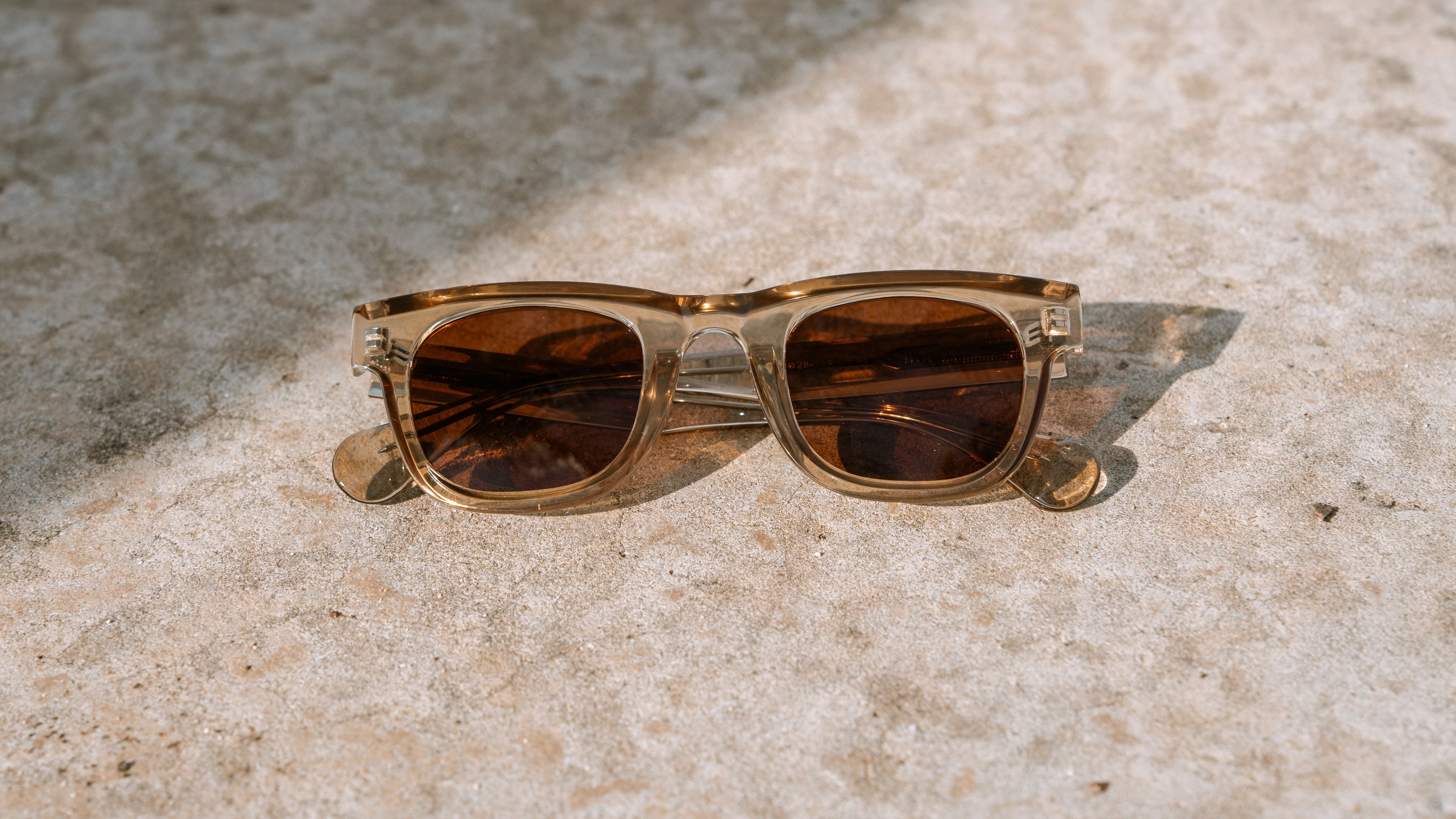Brown sunglasses on a textured stone surface